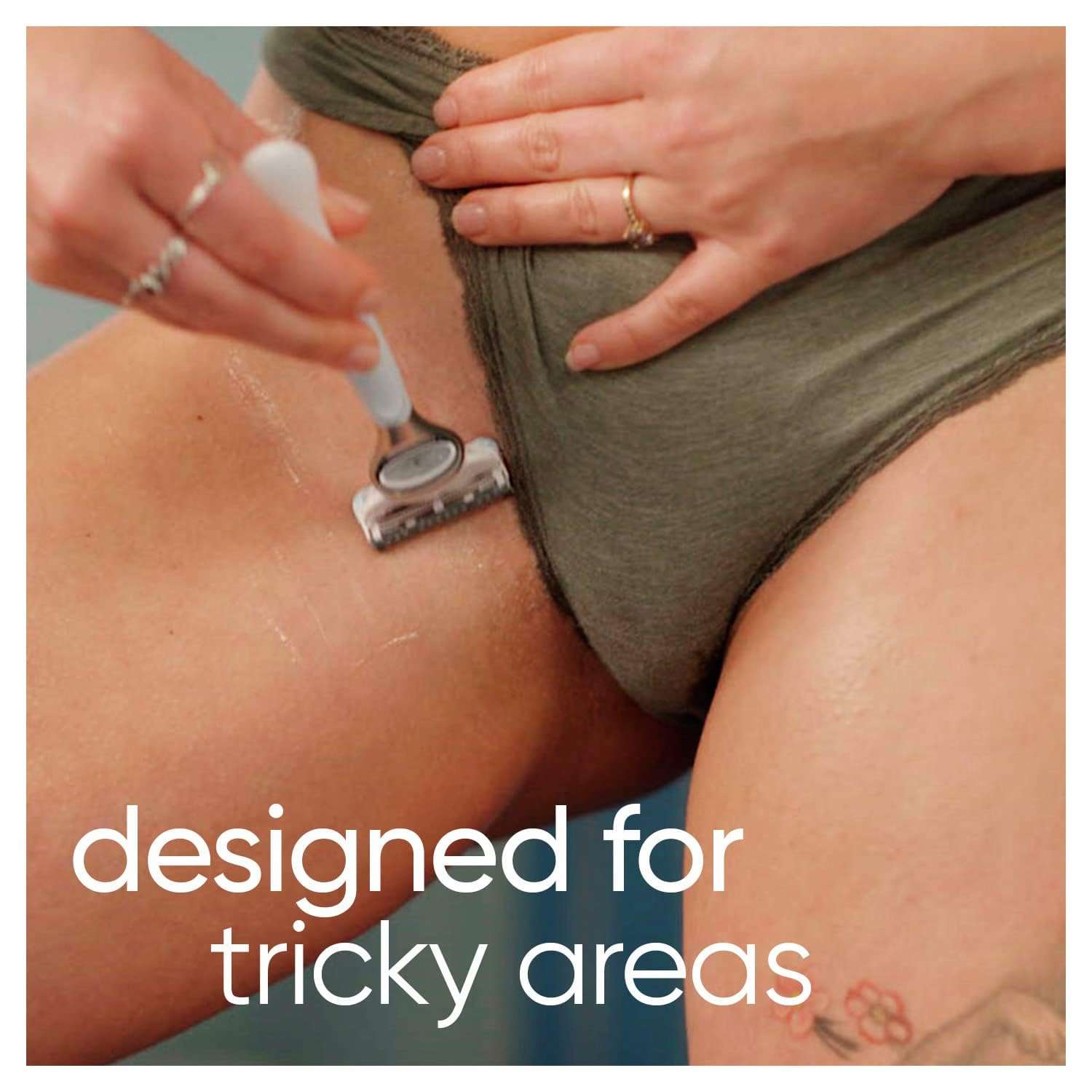 Close up of woman shaving bikini line with white handled razor on wet skin women's bikini razor blades
