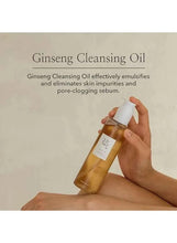 Ginseng Cleansing Oil 210ml bottle held in hand with label on amber glass