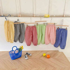 Variety of girls plaid summer pants in multiple colors hanging on a rack for stylish summer outfits