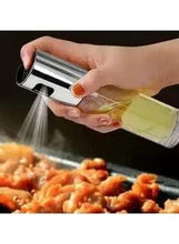 Olive oil spray bottle with stainless cap, pouring a stream of oil mist