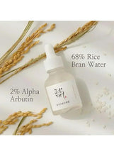 Skincare serum bottle with dropper near rice bran water and alpha arbutin text