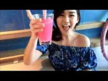 Woman holding a pink berry drink in a glass