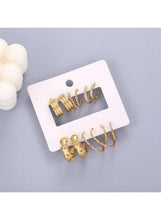 Assorted gold hoop earrings with three hoop pairs and three cuff hoops on card