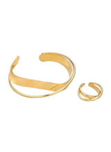 Gold alloy cuff bracelet and matching ring set, polished finish.