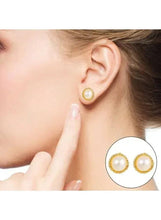 Woman wearing gold-tone faux pearl hoop earrings with matching stud detail