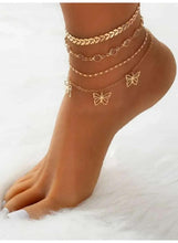 Gold layered anklets on ankle with butterfly charms and a twisted rope band