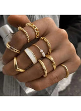 Gold-tone ring set on hand with pearl bead accents and textured bands