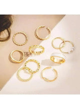 Gold-tone mixed ring set with pearl and butterfly-style design, six rings on surface