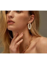 Pearl hoop earrings with gold-tone posts, worn by model in side profile