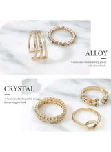 Gold-tone ring set with textured bands and small clear stones, laid out