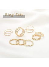 Gold-tone ring set with curved wire bands, braided rings, and beaded oval band