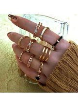 Gold-tone fashion ring set on hand, mix bands with blue and black stones.