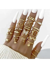 Gold-tone rings on a model’s fingers, featuring square and floral style bands