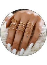 Gold-tone ring set on hand in circular crop, mixed bands and small stones