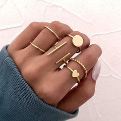 Huitich gold fashion rings set with various minimalist designs on a hand with a blue sleeve