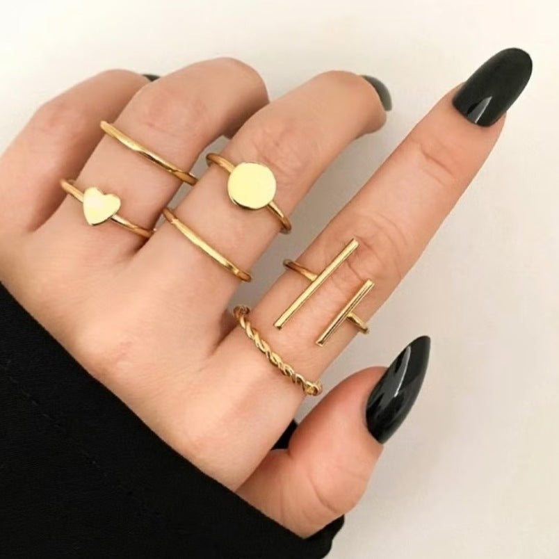 Huitich gold fashion rings set featuring various thin gold rings with heart, circle, and bar designs on a hand