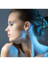 Side profile showing gold-tone pearl drop and stud earrings