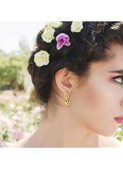 Woman wearing Huitich gold heart pendant jewelry set earrings with floral hair accessories outdoors
