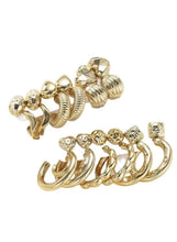 Gold hoop earrings and studs with rhinestone details, grouped together in gold tones