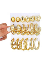 Gold hoop and stud earring set with geometric accents, shown on card with assorted sizes