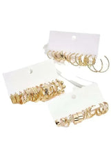 Gold-tone hoop earrings set with mixed sizes, arranged on white display card