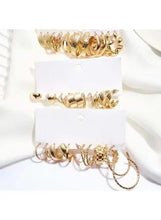 Gold-tone hoop earrings set on two hanging cards with assorted hoop styles