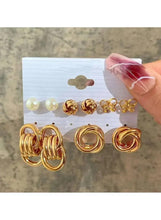 Gold-tone earring set with pearl discs, knotted hoop studs, and small floral studs