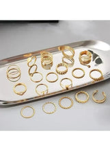 Gold tone knuckle ring set on tray, mixed textures and circular bands