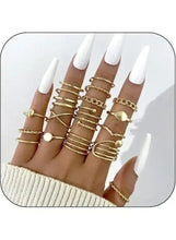 Gold tone knuckle rings stacked on fingers with round detail bands
