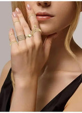Gold tone knuckle and finger rings on hand, close-up on stacked bands