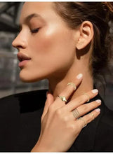 Gold tone knuckle rings worn on hand by woman in profile