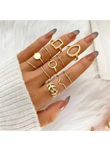 Gold-tone minimalist geometric ring set worn on hand, mix of square, oval, and circle bands.