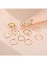 Gold-tone ring set on a light background, assorted geometric bands and oval accents (11 pcs).