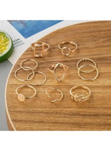 Gold-tone geometric ring set laid on a wooden tray, multiple minimalist shapes (11 pcs).