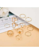 Gold-tone geometric ring set arranged on paper, mix of square, circle, and textured bands (11 pcs).