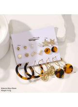 Earring set on display card with gold-tone and tortoise-look hoops, studs, and star accents