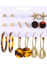 Earring set with gold studs, bar pins, star designs, and tortoise-look round earrings