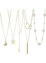 Gold tone necklace set with star, butterfly, bar and pearl drop chains