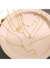 Gold tone necklace set with pearl bead chains, ring charm and small star pendant