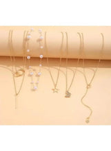 Gold tone necklace set with pearl beads and star, bar, and heart pendants