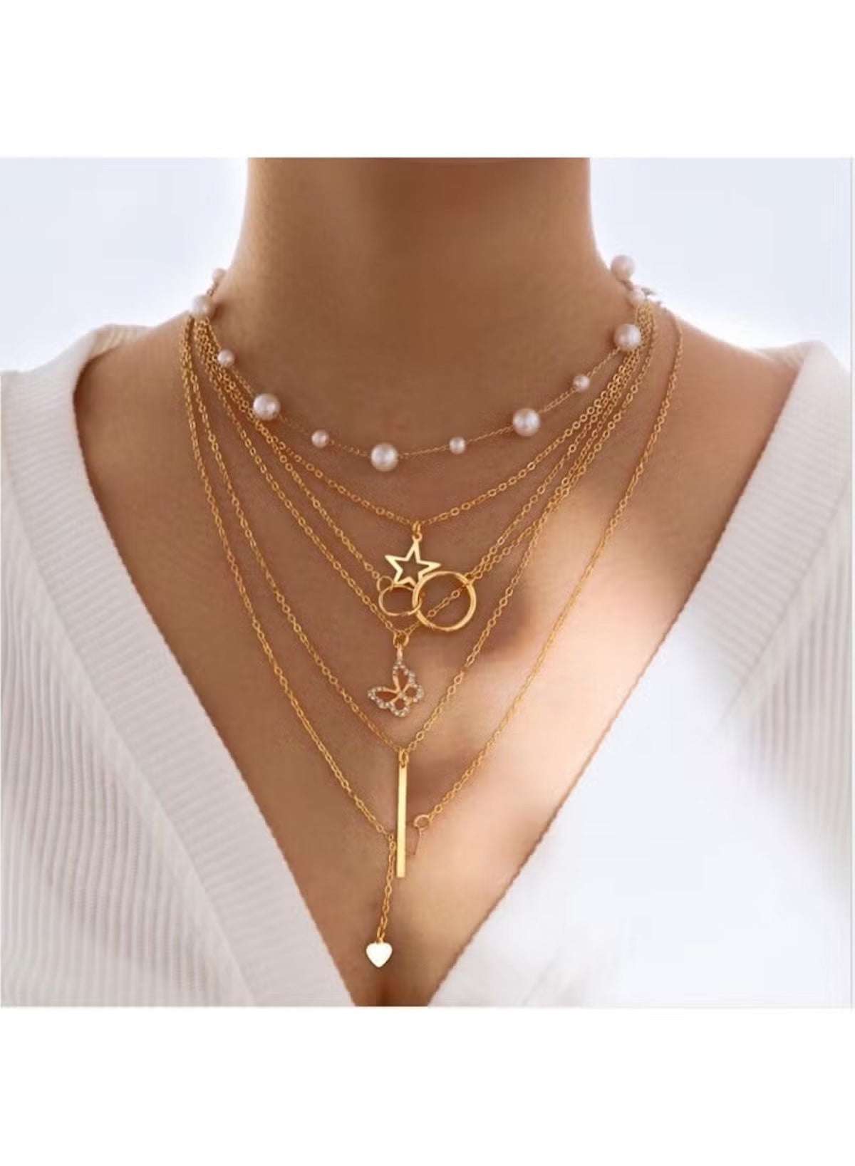 Stylish gold necklace set for women featuring layered chains and decorative charms