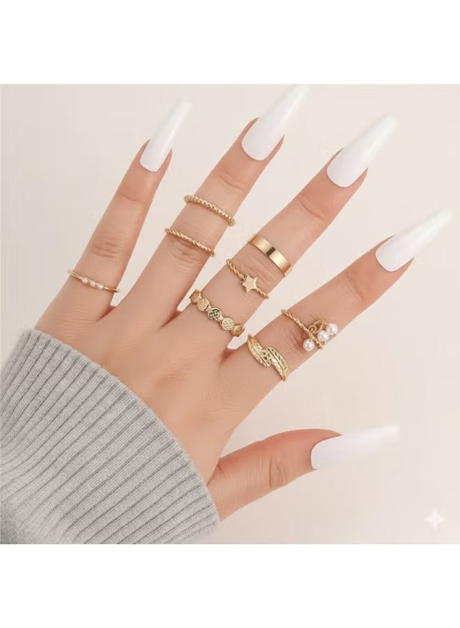 Gold plated women’s ring set displayed on a hand with long white nails and a gray sweater