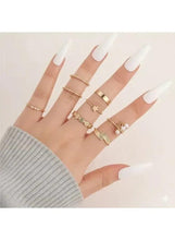 Gold-tone plated ring set on hand with stacked slim bands and gemmed rings