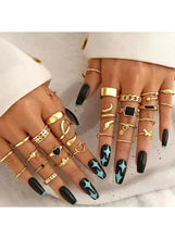 Gold-tone ring set on hands, mix of geometric and heart bands with black squares