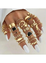 Gold-tone fashion ring set on hands, thick bands with black square accents