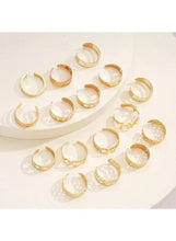 Gold tone ring set with mixed band designs, arranged in a cluster