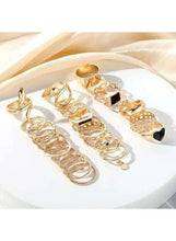 Gold-tone ring set on white surface, assorted linked bands with stones