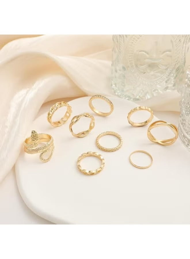 Gold snake ring set for women featuring various styles on a white plate with elegant drapery