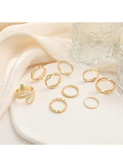 Gold snake ring set for women featuring various styles on a white plate with elegant drapery