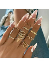 Gold snake and chain ring set on hand: layered stack of nine rings